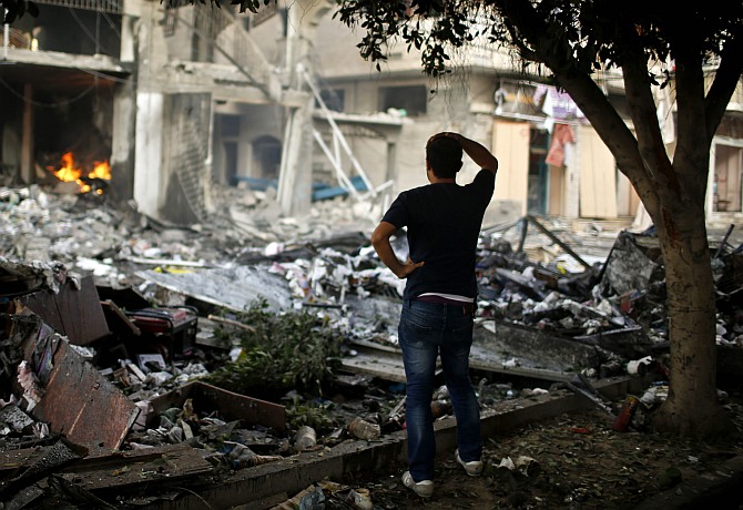 A Palestinian man looks at a house which police said was hit in an Israeli air strike, in Gaza City July 11