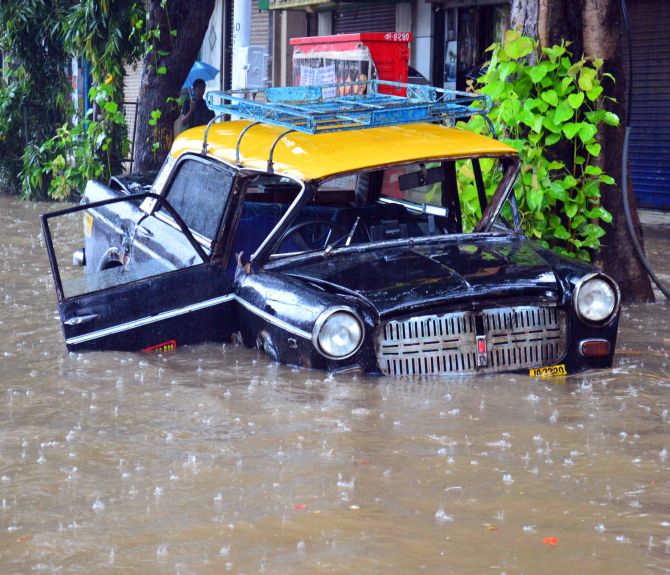 A taxi submerges as rains flood roads in Mumbai