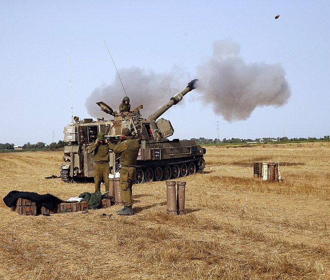 An Israeli mobile artillery unit fires towards Gaza from outside the central Gaza Strip July 12