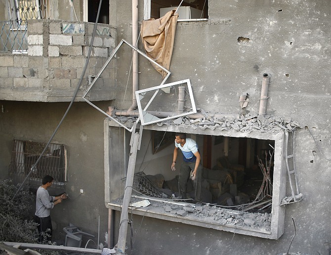 A Palestinian surveys a house which police said was damaged in an Israeli air strike on a neighboruing house in the northern Gaza Strip July 12