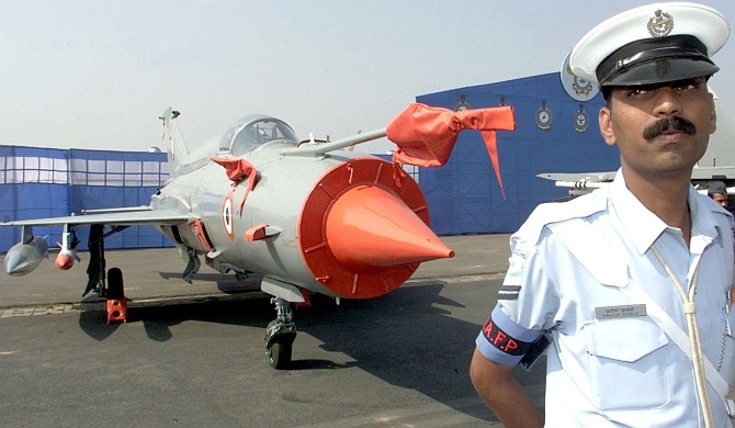 An Indian Air Force officer stands in front of a MiG-21 fighter