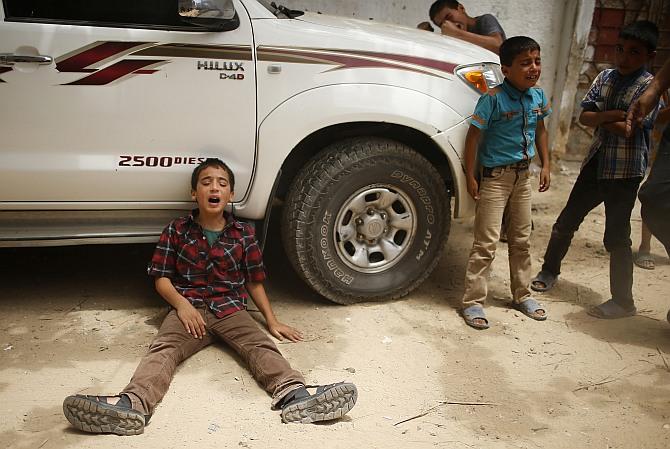 The son (left) of one of the Palestinian members of Tayseer Al-Batsh's family, who hospital officials said were killed in an Israeli air strike, mourns during their funeral in Gaza City. The Israeli air strike on the family home of Al-Batsh, Gaza's police chief, killed 18 people on Saturday, Gaza's health ministry said