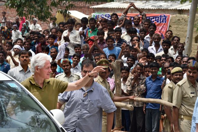 Former US President Bill Clinton waves upon his arrival at Mohanlal-Ganj in Lucknow district