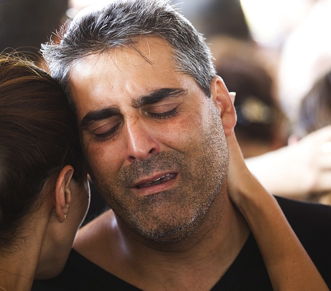 The brother of Dror Khenin mourns during his brother's funeral in Yehud, east of Tel Aviv, after Khenin was killed on Tuesday when a short-range rocket landed near the border with Gaza