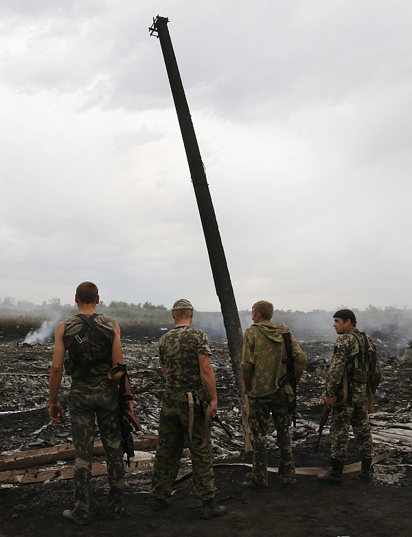 Armed pro-Russian separatists stnad at the site of a Malaysia Airlines Boeing 777 plane crash near the settlement of Grabovo in the Donetsk region,
