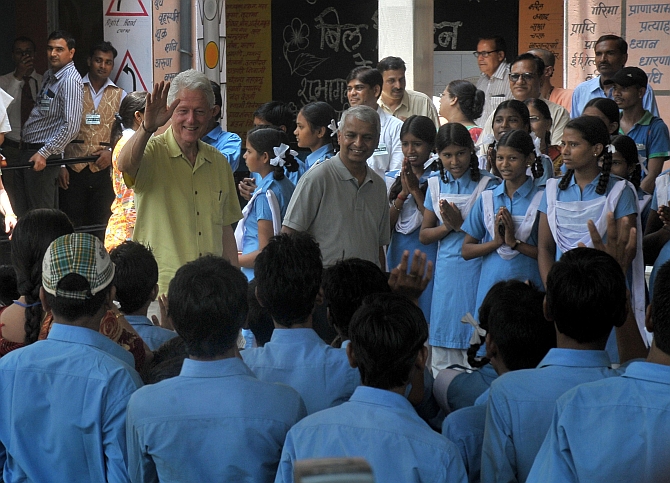 Former US president Bill Clinton waves to students 