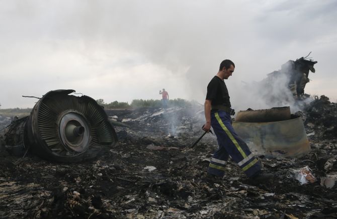 An Emergencies Ministry member (front) walks at the site of a Malaysia Airlines Boeing 777 plane crash near the settlement of Grabovo in the Donetsk region.