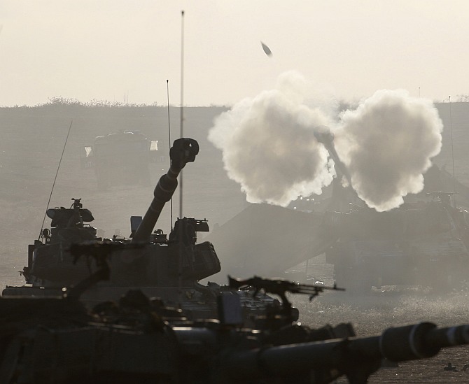 An Israeli mobile artillery unit fires towards Gaza from outside the northern Gaza Strip