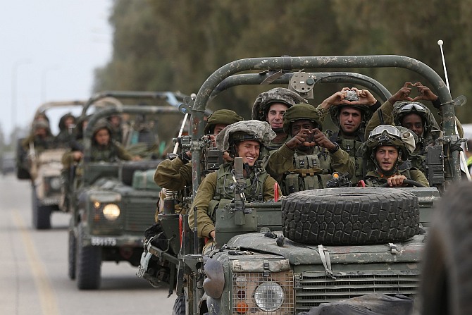 Israeli soldiers ride army jeeps near Sufa, outside the southern Gaza Strip