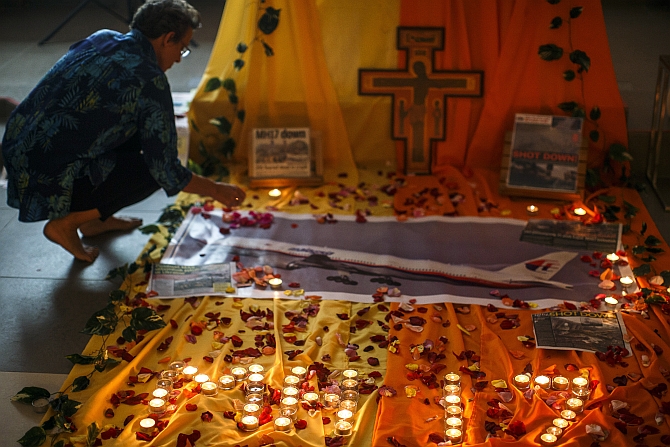 A woman lights candles at a memorial for victims of the downed Malaysia Airlines Flight MH17 in Kuala Lumpur