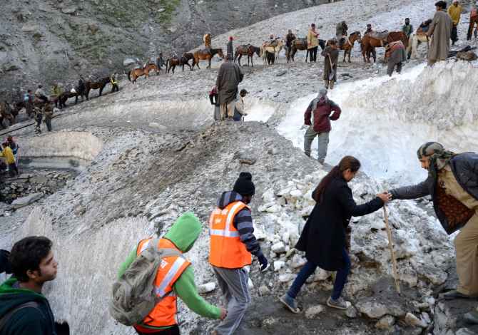 Security personnel assist the pilgrims proceeding towards the Holy Amarnath cave on Saturday
