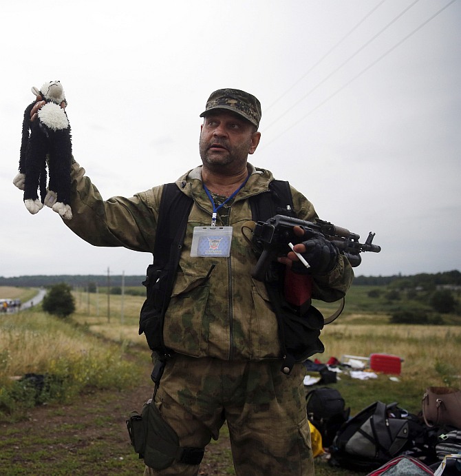 A pro-Russian separatist holds a stuffed toy found at the crash site of Malaysia Airlines flight MH17, near the settlement of Grabovo in the Donetsk region