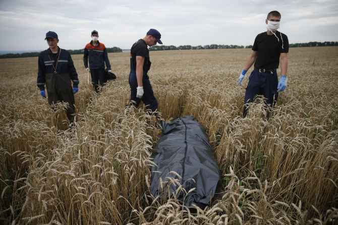 Members of the Ukrainian Emergency Ministry prepare to remove a body at the crash site near Grabovo