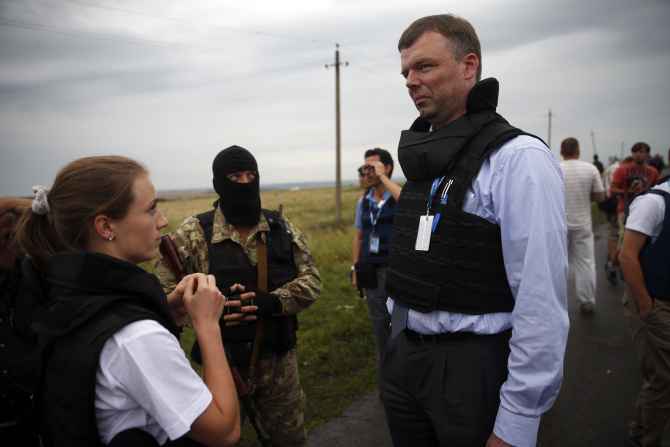 OSCE monitors speak with a pro-Russian separatist at the crash site