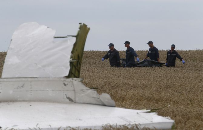 Members of the Ukrainian Emergency Ministry carry a body at the crash site of Malaysia Airlines Flight MH17, near the settlement of Grabovo in the Donetsk region.