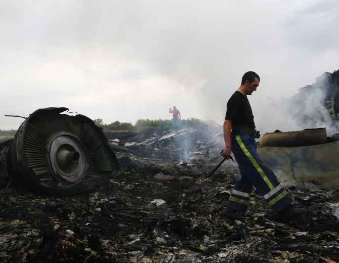An Emergencies Ministry member walks at the site of a Malaysia Airlines Boeing 777 plane crash near the settlement of Grabovo