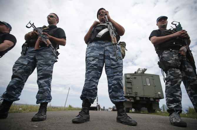 Armed pro-Russian separatists stand guard at a crash site of Malaysia Airlines Flight MH17