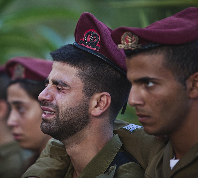 Israeli soldiers mourn during the funeral of their comrade Bnaya Rubel in Holon, near Tel Aviv
