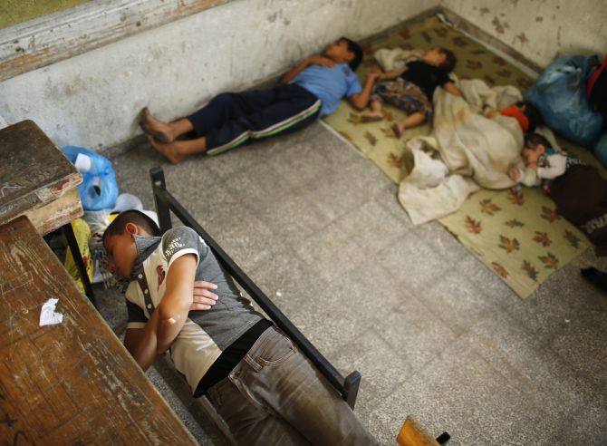 Palestinian children, who fled their family house that is adjacent to the border with Israel, sleep as they stay at a United Nations-run school in Gaza city.