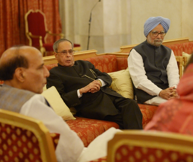 President Pranab Mukherjee speaks to Union Home Minister Rajnath Singh as former Prime Minister Manmohan Singh looks on