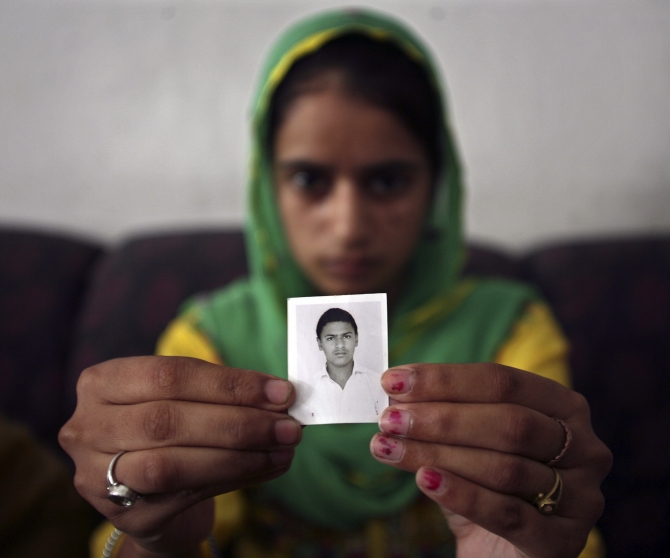 Paramjit Kaur displays the photograph of her brother Kuljit Singh, who has been kidnapped in Iraq, in Amritsar.