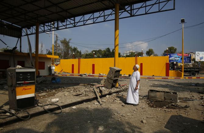A Palestinian man looks at a petrol station which police said was damaged in an Israeli air strike, in Gaza City