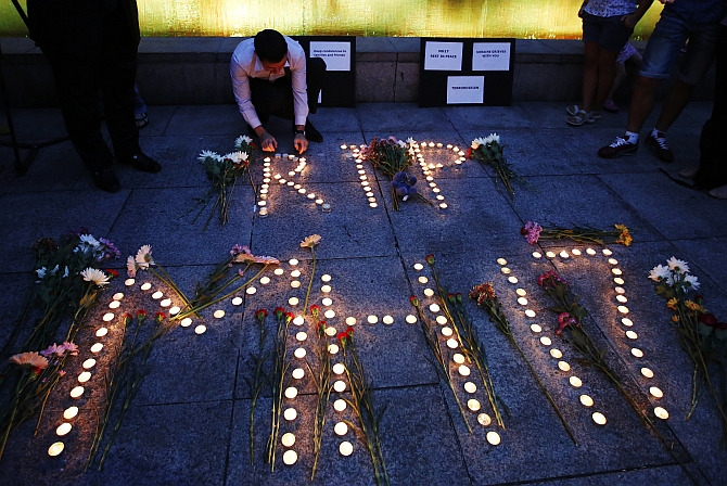 A man from the Ukrainian community living in Malaysia lights candles for a memorial to the victims of Malaysia Airlines Flight MH17, which was downed over eastern Ukraine, in Kuala Lumpur 