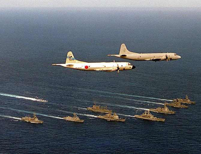 A US navy P-3 Orion submarine hunter plane leads a Japanese P-3 in flight over a bilateral force of US and Japanese ships during a military exercise in the Pacific Ocean