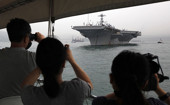 Journalists take photos of US aircraft carrier USS George Washington during its port call in the Hong Kong waters