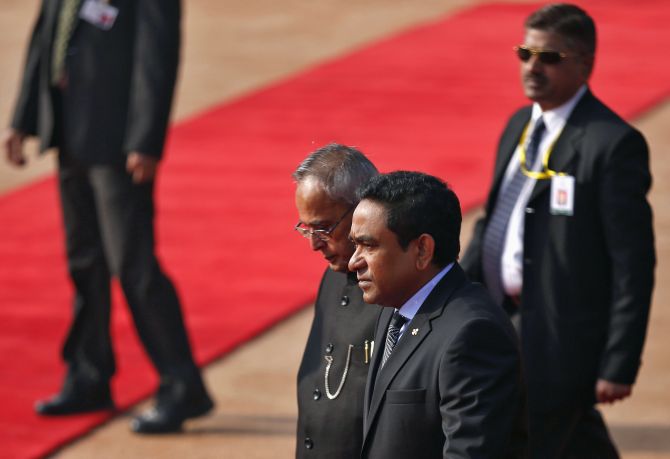 Maldives President Abdulla Yameen (2nd R) and his Indian counterpart Pranab Mukherjee (C), surrounded by security personnel, walk during Yameen's ceremonial reception at the forecourt of India's presidential palace Rashtrapati Bhavan in New Delhi January 2, 2014