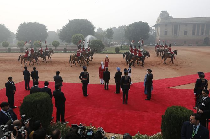 India's President Pranab Mukherjee (C) and India's the prime minister Manmohan Singh (blue turban) wait to receive South Korean President Park Geun-Hye during a ceremonial reception at the forecourt of India's presidential palace Rashtrapati Bhavan in New Delhi