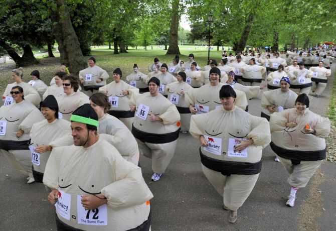 dressed in inflatable Sumo costumes take part in a charity run.