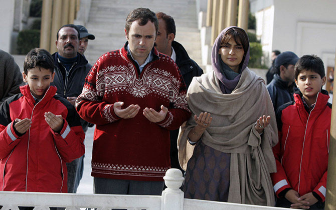 Omar Abdullah, president of the National Conference, prays with his two sons and his wife while standing beside the grave of Sheikh Mohammed Abdullah, his grandfather, in Hazratbal on the outskirts of Srinagar.