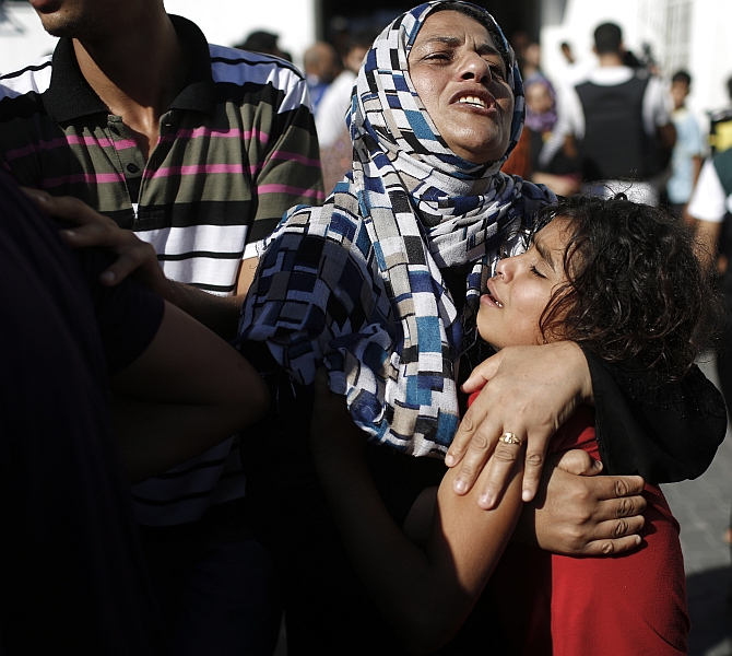 A Palestinian mother comforts her child after what medics said was an Israeli shell that hit a the school sheltering Palestinian refugees, at a hospital in Jabaliya in the northern Gaza