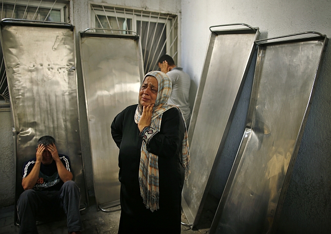 Relatives of Palestinians, whom medics said were killed in Israeli shelling, mourn outside the hospital morgue