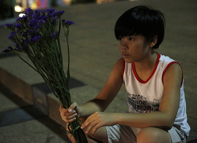 A boy waits to place flowers at a vigil for victims of Malaysia Airlines Flight MH17 in Kuala Lumpur.