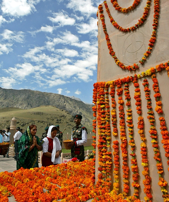 Relatives of Indian soldiers killed in a war with Pakistan pray in front a war memorial during 'Vijay Diwas' celebrations in Drass 1