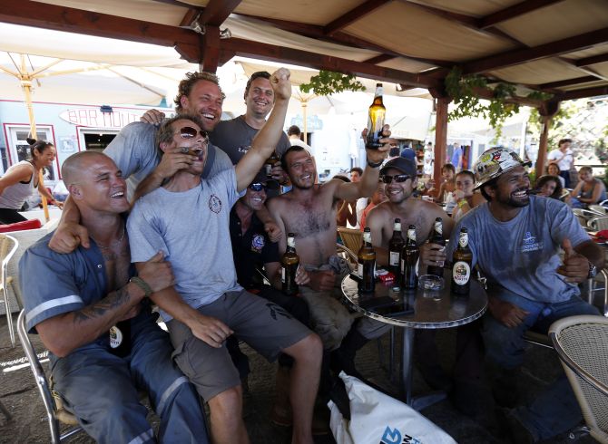 Dutch salvage workers celebrate after the refloat operation maneuvers that allowed cruise liner Costa Concordia to leave Giglio Island.