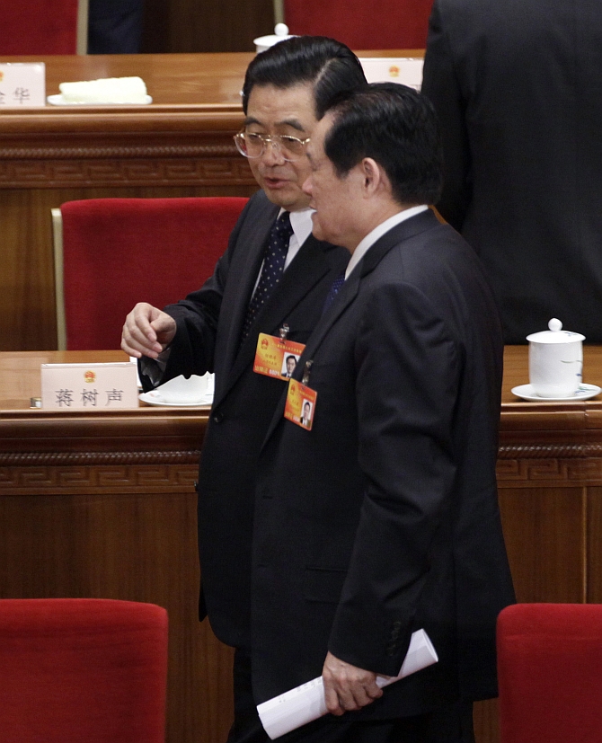 Zhou Yongkang talks with former China's President Hu Jintao after a plenary session of the National People's Congress at the Great Hall of the People, in Beijing