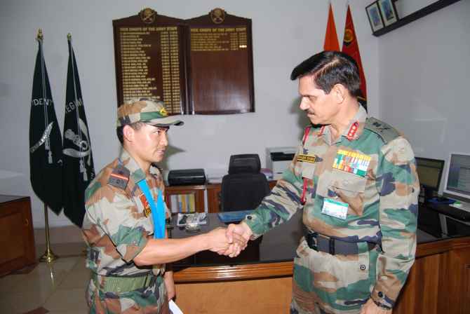 Lt General Singh felicitating a young soldier for his bravery