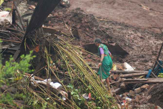 A woman seen near her house which was destroyed by the landslide