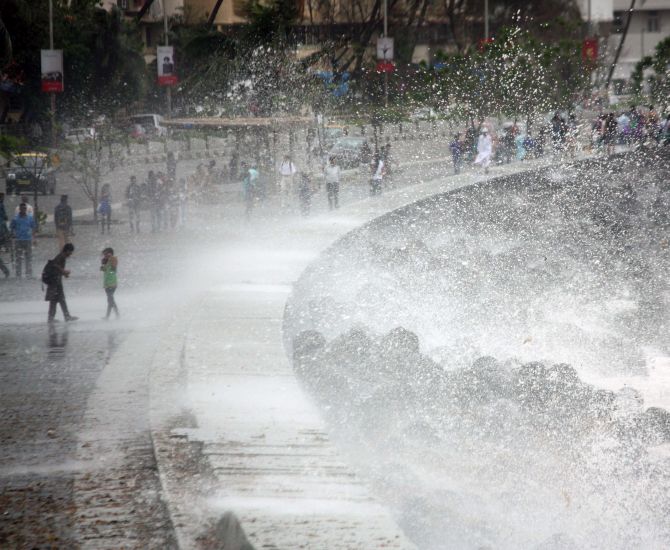 Two children enjoy the waves of the water lashing against the rocks at Marine Drive on Tuesday.
