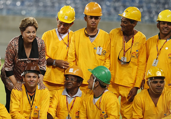 Brazil President Dilma Rousseff poses with workers during the opening ceremony of the Arena das Dunas stadium
