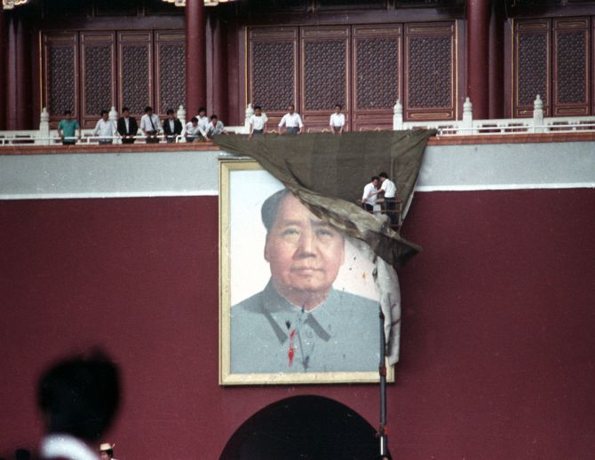 Workmen try to drape the portrait of Mao Tse-tung in Beijing's Tiananmen Square after it was pelted with paint.
