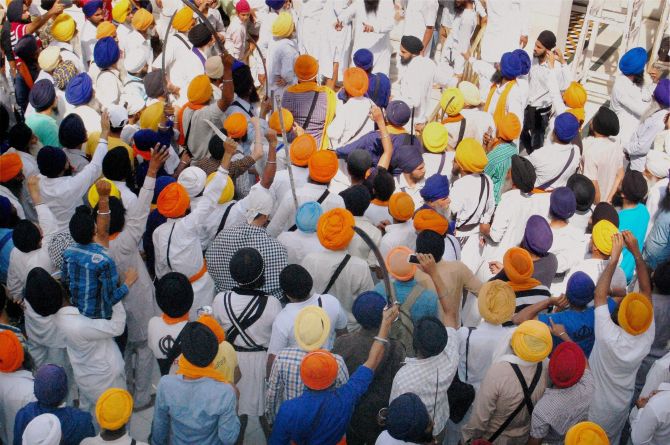 Sikh men brandishing swords during a clash between SGPC supporters and a radical Sikh organisation on the 30th anniversary of Operation Bluestar, at Golden Temple Complex in Amritsar
