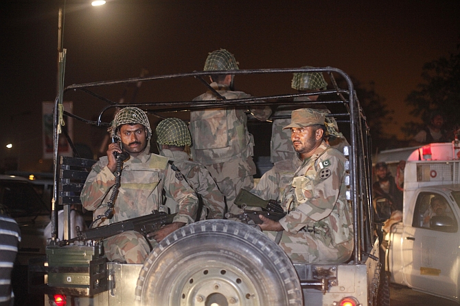 Pakistan army soldiers sit on a vehicle as they arrive at Jinnah International Airport in Karachi 