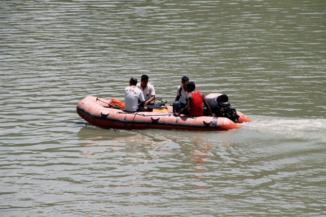 ITBP jawans carry out a rescue operation in Beas River near Pandoh Dam in Mandi on Monday a day after 24 engineering students from Hyderabad were washed away in the River near Thalot following discharge of water from Larji Dam.