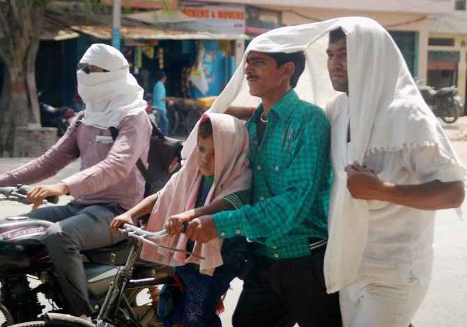 Men cover their heads to protect themselves from the sorching heat in Varanasi, Uttar Pradesh