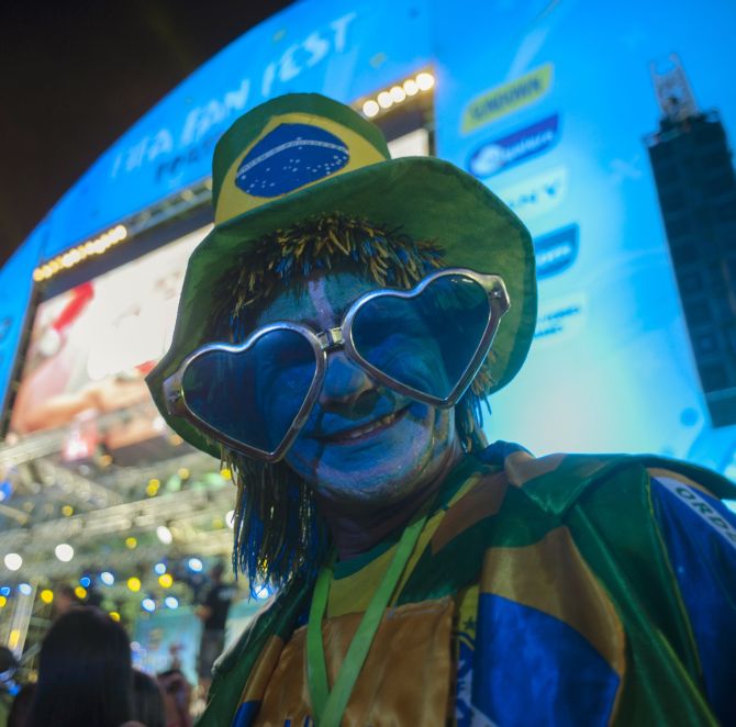 A fan dresses in the colours of the Brazilian flag hours before the World Cup kicks off.