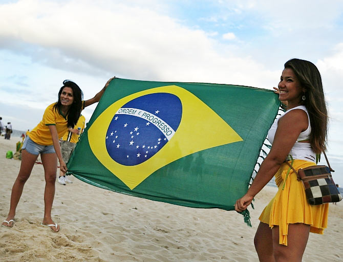 Brazilian soccer fans display a Brazilian flag before the opening match of the 2014 World Cup between Brazil and Croatia at the Copacabana beach in Rio de Janeiro